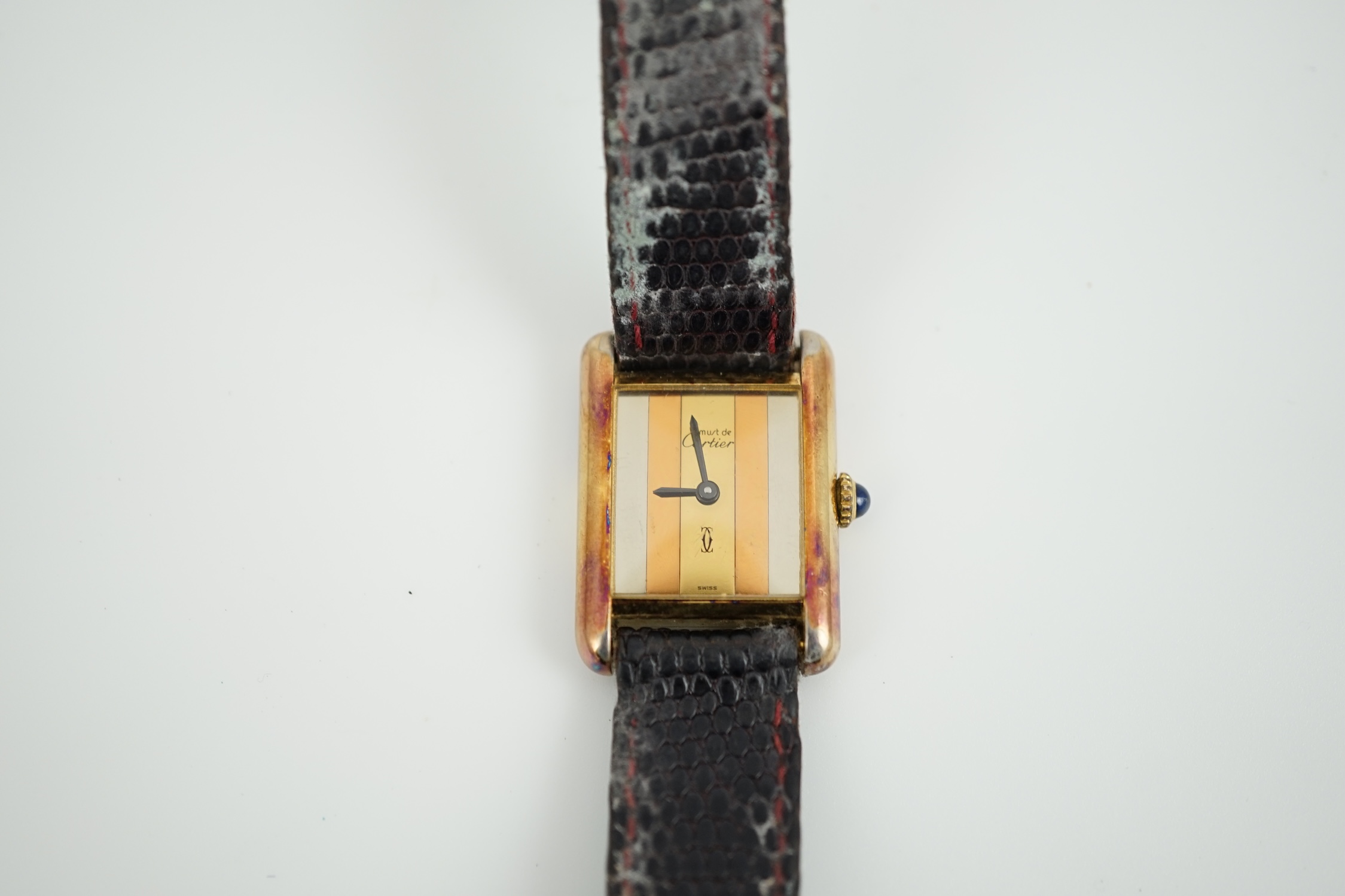 A lady's silver gilt Must De Cartier rectangular dial manual wind wrist watch, case diameter 20mm, on a leather strap.